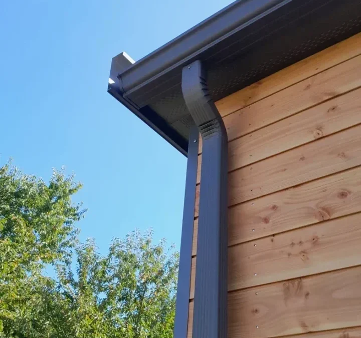 Gouttière et descente d’eau pluviale sur une maison en bois